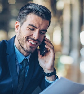 Businessman holding documents and talking on the phone